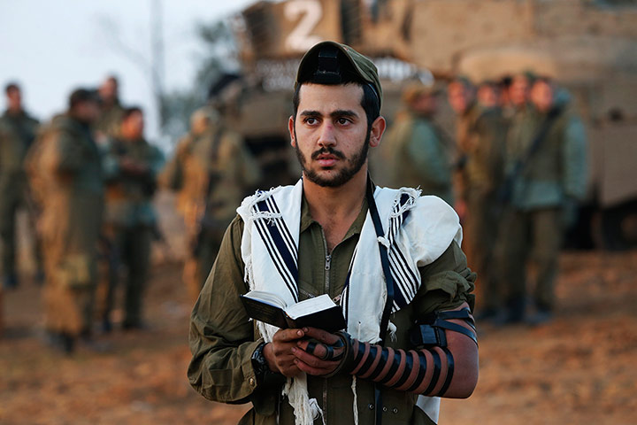 Israel Gaza : An Israeli soldier prays at a staging area near the Israel Gaza Strip