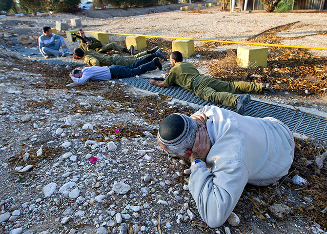 Israel Gaza : An Israeli man covers his head by the roadside in Beersheba, Israel