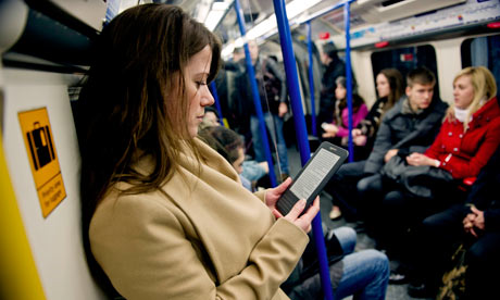 Young woman reading Kindle on London Underground