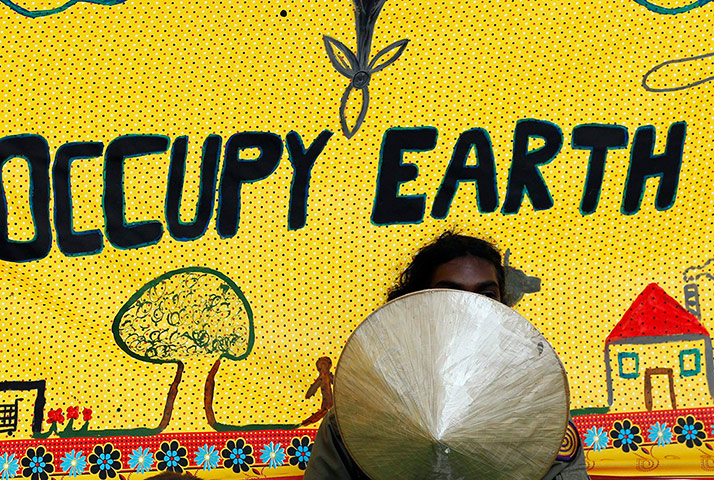 Kyoto history: A protester gestures in front of a banner outside  the COP17 in Durban
