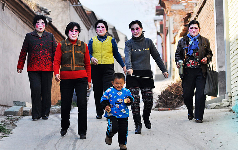 24 hours: Xihuang, China: Performers walk home after their opera show