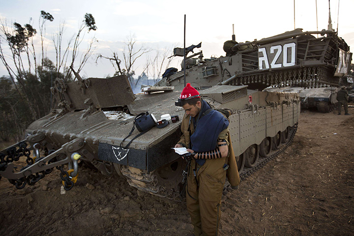 24 hours: Israel-Gaza Strip border: An Israeli soldier performs morning prayers