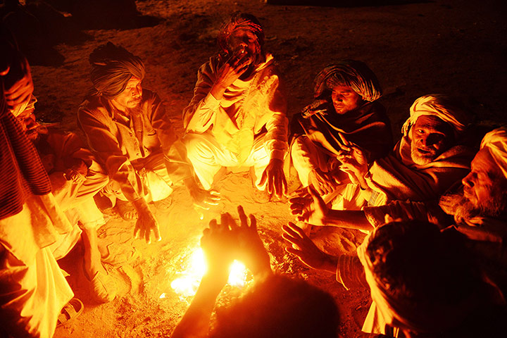 Camel fair: Camel traders sit around a fire before dawn