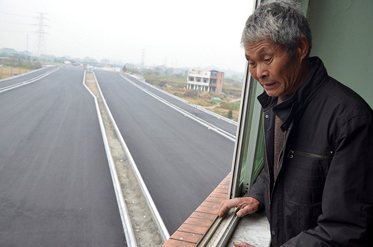 China demolition: An old man looks down from his house 