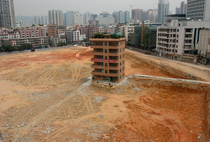 China demolition: A house stands isolated in the middle of a construction site