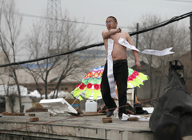 China demolition: Li Shuguang stands on top of his house