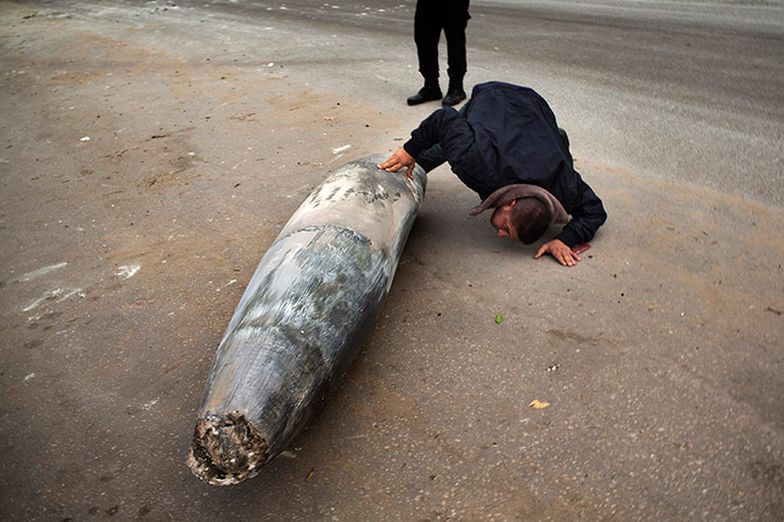 Bernat Armangue: A Hamas officer inspects an unexploded Israeli missile in Gaza City