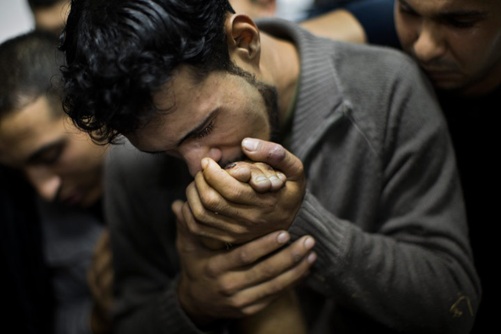 20 Photos: A Palestinian man kisses the hand of a dead relative in Gaza City