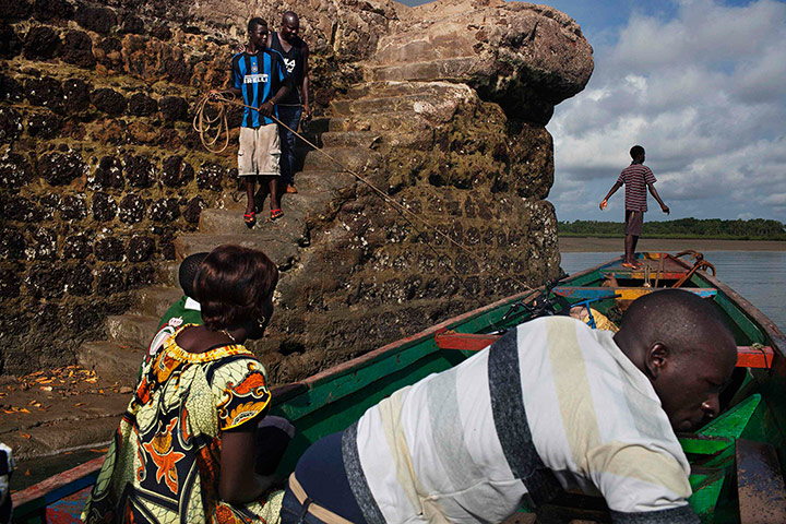 20 Photos: People leave colonial-era dock on the island of Bolama by pirogue