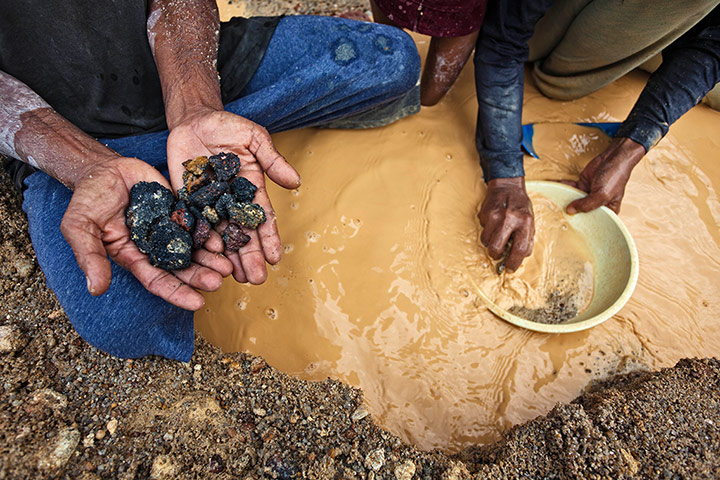 Tin Mining: A miner shows tin rocks at a PT Timah tin ore mine in  in Tanjung Pesona