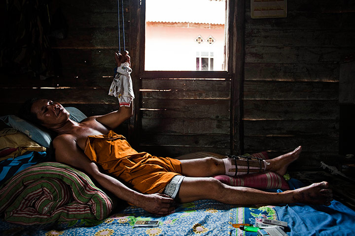 Tin Mining: Suge, a sea tin miner, lying in bed at his home in Belo Laut Village