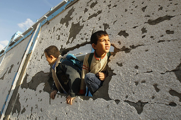 24 hours: Palestinian schoolboys look through a hole