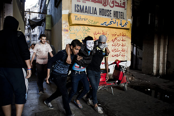 Anti-Morsi protests: An injured protester is led away from violent clashes
