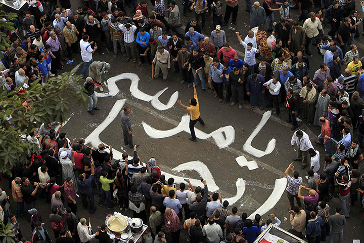 Anti-Morsi protests: Protesters write 'Go away Morsi' on the ground at Tahrir square