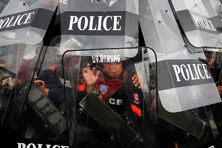 24 hours: Bangkok, Thailand: Police officers shield themselves during clashes