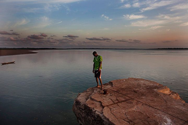 FTA: Joe Penney: Student Rachid Malam peers off the edge of a colonial-era dock, Bolama