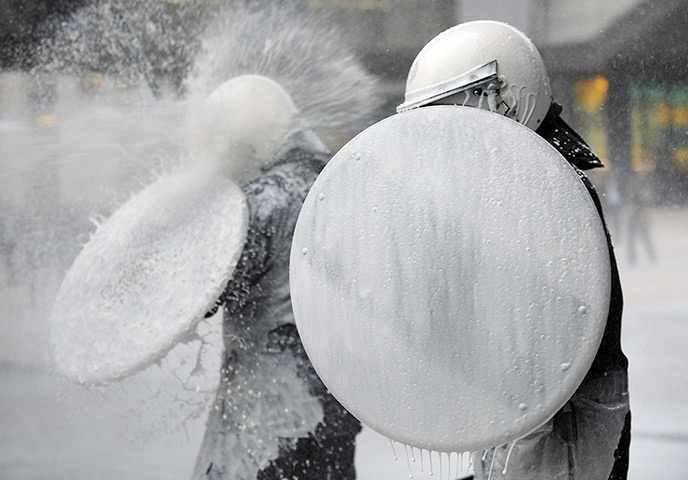 24 hours: Brussels, Belgium: A police officer protects himself from milk