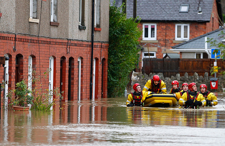 Residents rescued floods: A rescue crew help a resident to safety in St Asaph