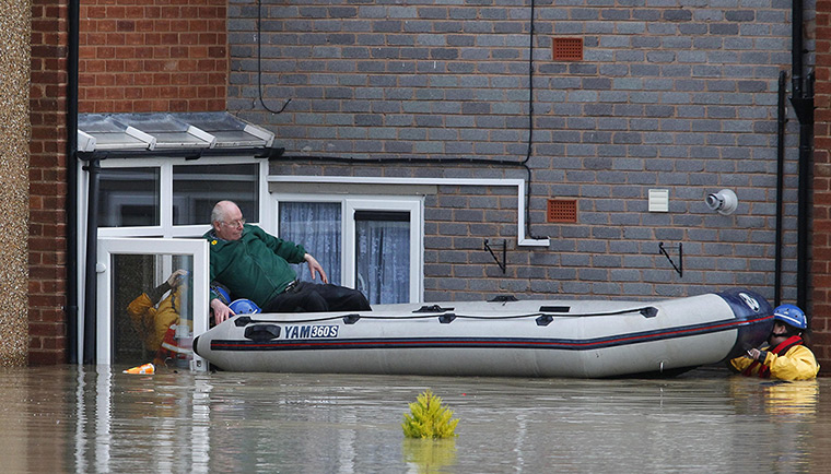 Residents rescued floods: A man climbs into a lifeboat in St. Asaph, Denbighshire, North Wales