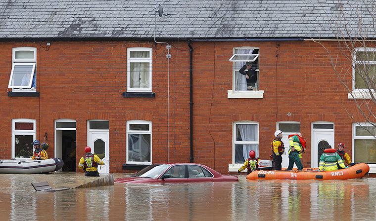 Residents rescued floods: A man looks out of a window in St Asaph