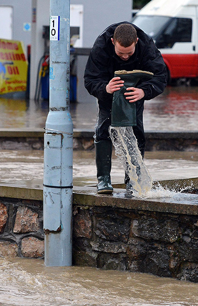 Residents rescued floods: A man empties water from his boot in St Asaph