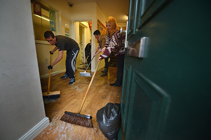 Floods clear-up: Residents sweep water from a property in Malton