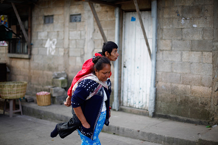 24 hours in pictures: Catalina Garcia piggybacks her son in Tierra Nueva