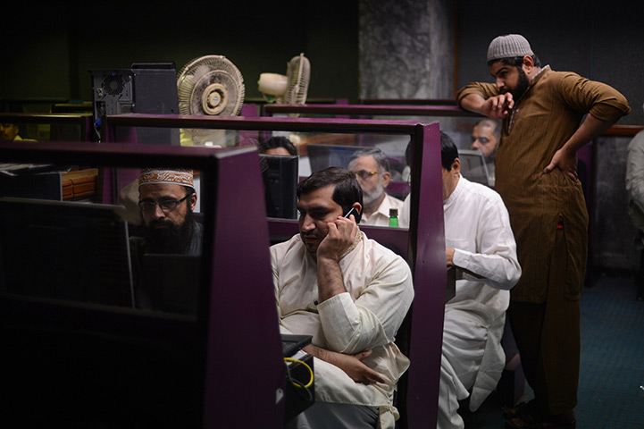24 hours in pictures: Pakistani stockbrokers watch share prices