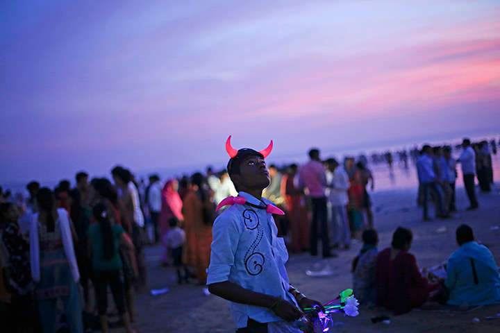 24 hours in pictures: A man wearing devil horn as he sells toys on a beach 