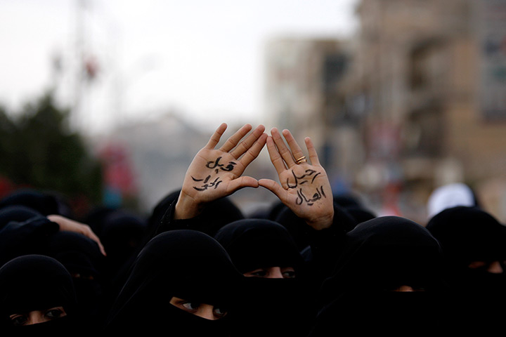 24 hours in pictures: A female protestor displays her hands painted, Yemen