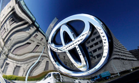 The Bank of Japan building is reflected on Toyota Motor Corp's Prius hybrid car in Tokyo