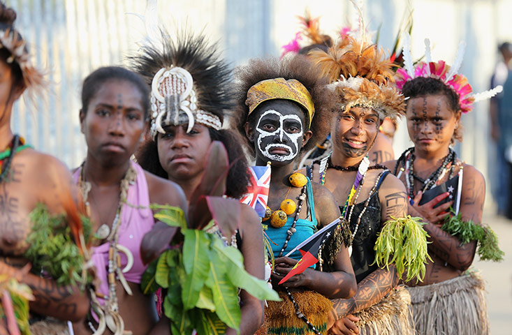 24 hours: Dancers in Papua New Guinea look on as Prince Charles and Camilla arrive at the airport