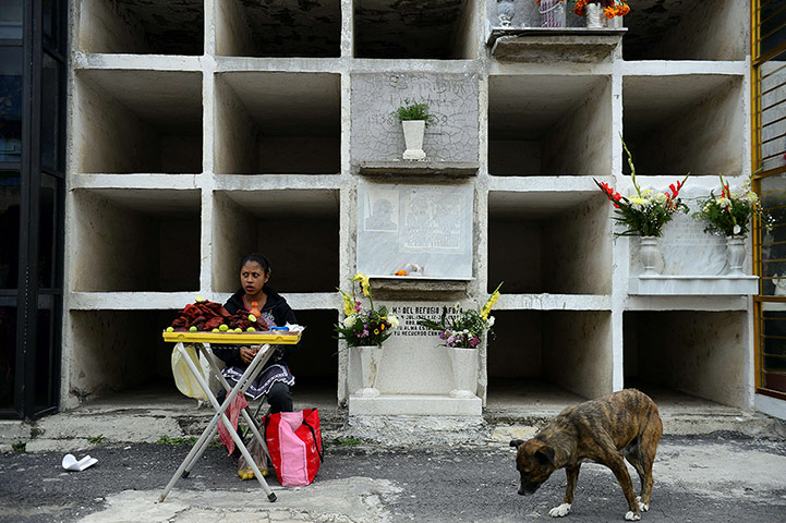 Twenty Photos: A street vendor in front of graves during the Day of the Dead in Mexico