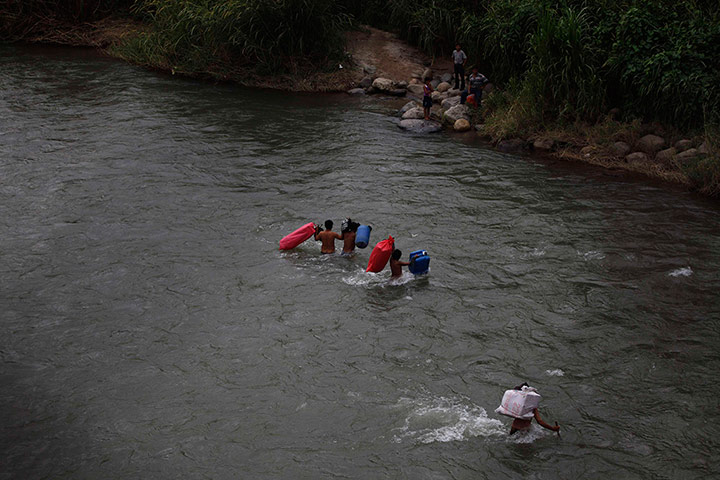 Twenty Photos: People cross the Suchiate river from Guatemala to Mexico in El Carmen