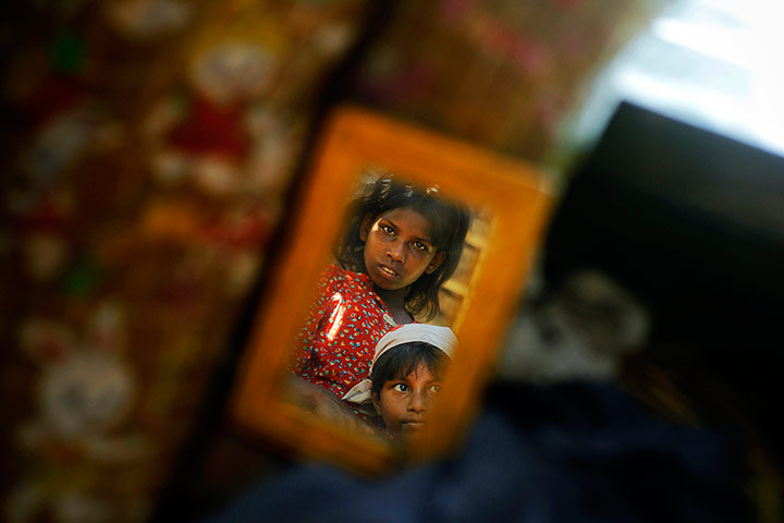 Twenty Photos: Children are reflected in a mirror at a Owntaw refugee camp