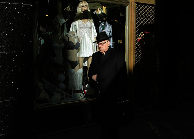 24 hours in pictures: A priest walks past a lingerie shop