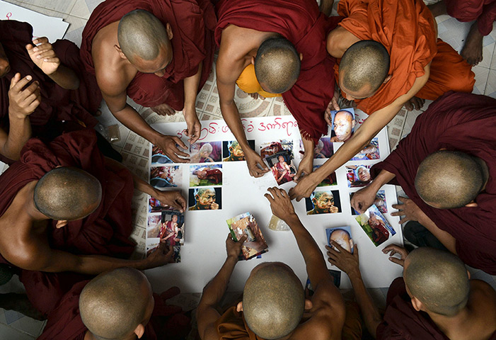 24 hours in pictures: Buddhist monks stick pictures of monks who were injured in a police clash