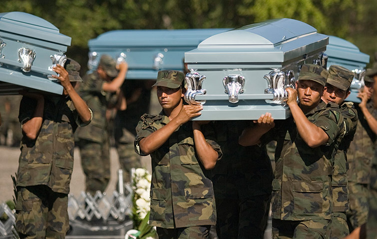 Mexico Drug Wars: December 2008: Soldiers carry coffins during the funeral of six men