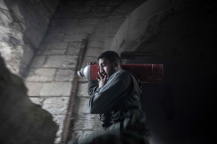 24 hours in pictures: a rebel fighter carries an improvised explosive device in Syria