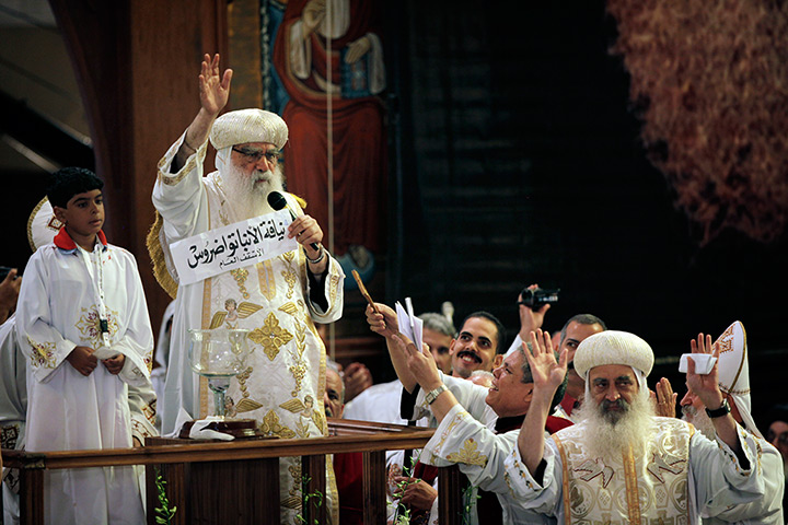 coptic pope elected: Acting Pope Pachomios holds up the name of the name of Bishop Tawadros