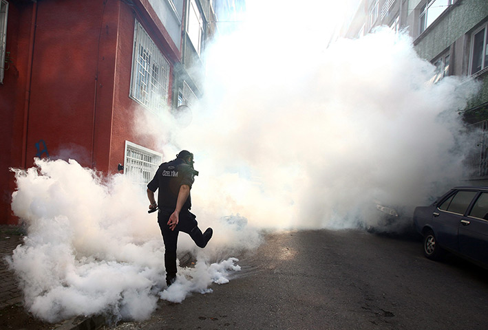 24 hours in pictures: A Turkish riot policeman kicks away a gas canister 