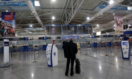 A passenger looks at an announcement board inside the Athens Eleftherios Venizelos airport a few hours before a work stoppage by flight controllers begins in Athens November 6, 2012. 