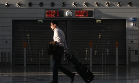 A passenger walks in front of a closed entrance of a suburban railway station at the Athens Eleftherios Venizelos airport in Athens November 6, 2012. 