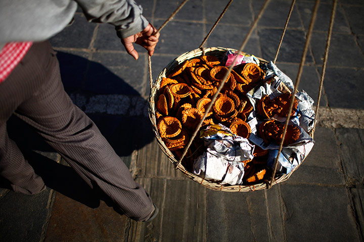 24 hours: Katmandu, Nepal: An Indian vendor carries earthen lamps for sale