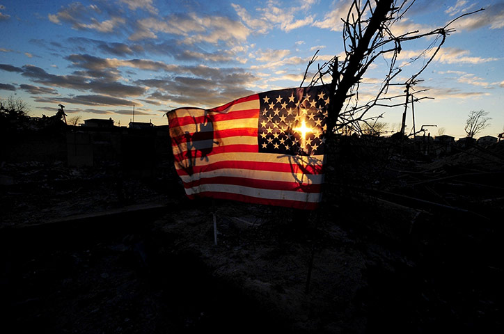 24 hours: New York, US: The sun sets behind an American flag