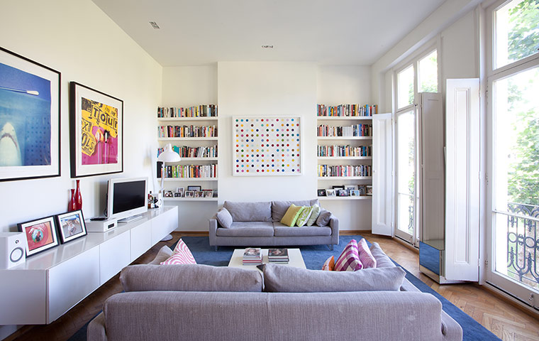 Homes: Little Venice: Living room with paintings on white walls and a grey sofa