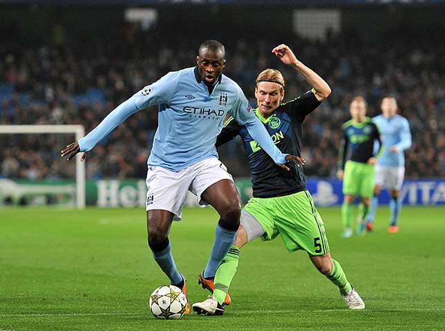 Tuesday CL action: Yaya Toure goes down under a challenge by Christian Poulsen
