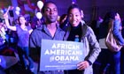 Supporters hold an 'African Americans for Obama' sign as they celebrate his re-election