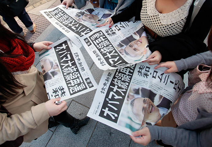 World election reaction: Tokyo, Japan: People read newspapers reporting Barack Obama's re-election