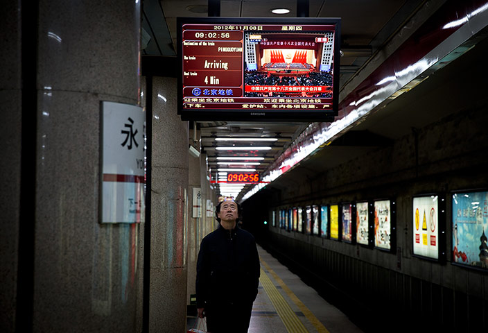China national congress: A man watches a live broadcast of the congress in a subway station, Beijing